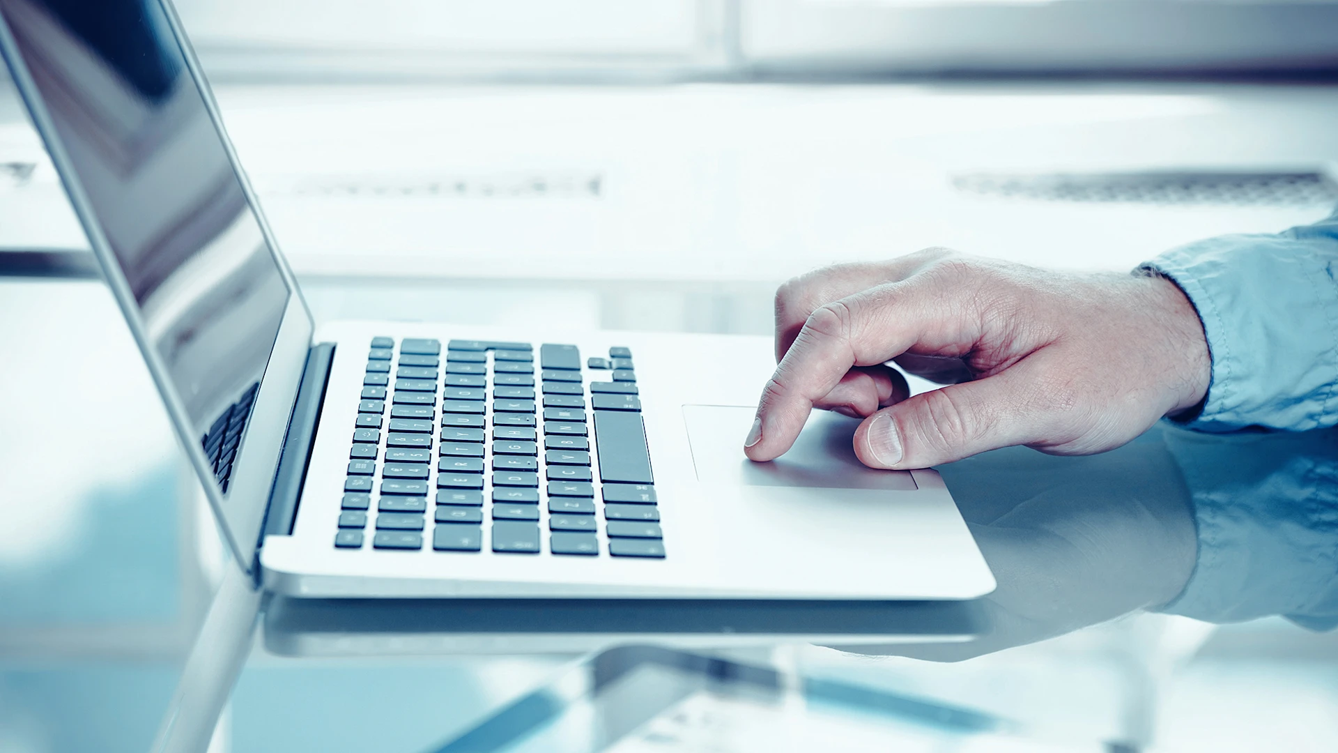 Close-up of a hand on a laptop.